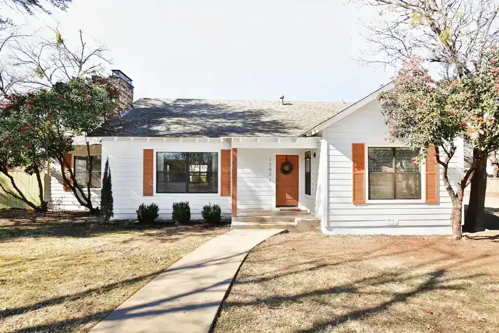 Grand Avenue from the front walk, white siding, cedar shutters and an orange front door